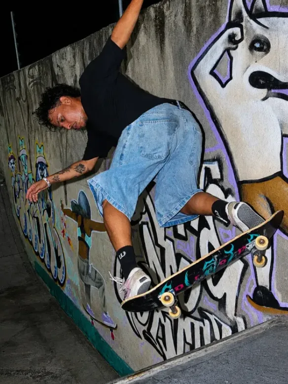 Skatista em manobra numa parede grafitada